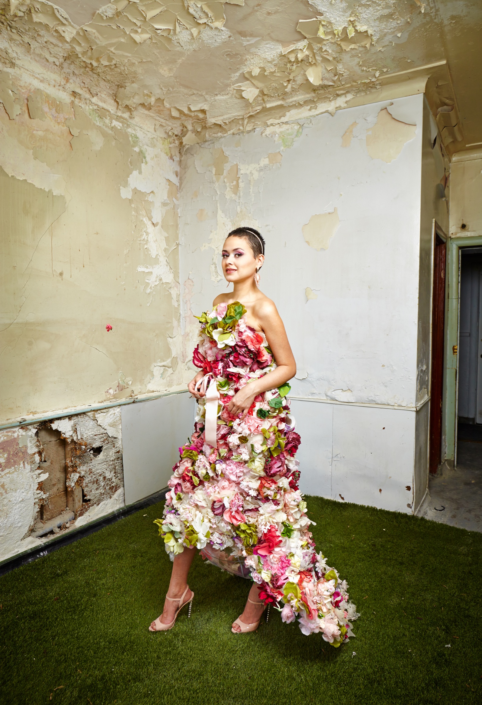 Lolitta Dandoy dans une robe florale, dans un décor brut